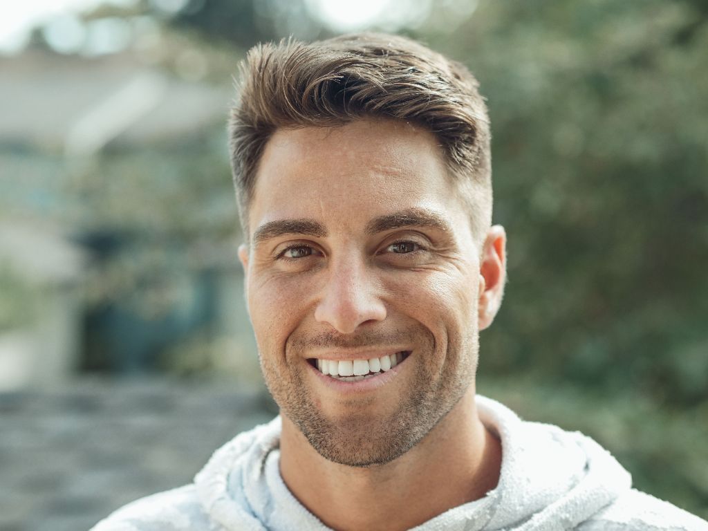 Smiling young man outdoors with friendly, approachable expression